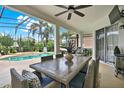 Covered outdoor patio features a large dining table, ceiling fan, and views of the screened-in pool area at 1932 Reed Hill Dr, Windermere, FL 34786