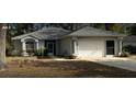 Charming single-story home featuring a two-car garage and well-maintained front yard at 19430 Sw 100Th Loop, Dunnellon, FL 34432