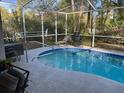 Screened-in pool with lounge chairs and privacy, perfect for relaxing outdoors at 19430 Sw 100Th Loop, Dunnellon, FL 34432