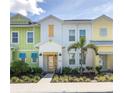 Colorful townhomes with a small palm tree and beautiful flower beds create a serene, tropical street view at 2923 Castaway Ln, Kissimmee, FL 34747