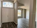 Inviting entryway with double doors and modern gray wood-look flooring at 307 Dalton Ct, Davenport, FL 33897