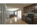 An open kitchen with dark cabinets, granite countertops, stainless steel appliances, and light tile flooring at 3223 Dragoon Pl, Orlando, FL 32818