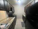 Efficient kitchen featuring dark wood cabinets, granite countertops, and stainless steel appliances at 3270 S Semoran Blvd # 15, Orlando, FL 32822