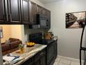 Cozy kitchen shows granite counters, dark cabinets, and black appliances at 3270 S Semoran Blvd # 15, Orlando, FL 32822