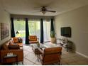 Bright living room features sleek leather furniture, modern ceiling fan, and sliding glass doors at 3270 S Semoran Blvd # 15, Orlando, FL 32822