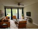 Bright living room featuring a ceiling fan, ample seating, and sliding glass doors to a patio at 3270 S Semoran Blvd # 15, Orlando, FL 32822