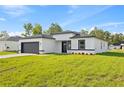 Charming single-story home featuring a modern design, black trim, and an attached two-car garage at 3749 Sw 131St St, Ocala, FL 34473