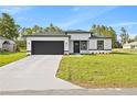 Charming single-story home featuring a modern design, black trim, and an attached two-car garage at 3749 Sw 131St St, Ocala, FL 34473