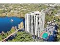 Stunning aerial view of a lakeside condominium complex with a pool, parking, and lush greenery at 400 E Colonial Dr # 910, Orlando, FL 32803