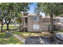 Inviting condo exterior with lush trees, private entrance, and convenient parking spaces at 5083 Eaglesmere Dr # A12, Orlando, FL 32819