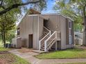 View of the condo's exterior featuring wood paneling, a private entrance, and manicured grounds at 5083 Eaglesmere Dr # A12, Orlando, FL 32819