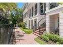 Landscaped brick pathway leading to the townhome's entrance, surrounded by lush greenery and a black fence at 524 Lanark Ct, Orlando, FL 32806
