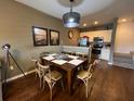 Cozy dining area with wooden table set, stylish light fixture, and adjoining kitchen at 5370 Diplomat Ct # 107, Kissimmee, FL 34746