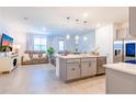 Open-concept living area featuring an island with seating and stainless steel appliances at 665 Longboat Dr, Davenport, FL 33896