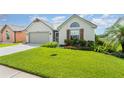 Well-maintained single-story home with green lawn, complemented by neat landscaping and a two-car garage at 685 Middlebury Loop, New Smyrna Beach, FL 32168