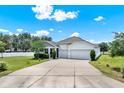 Inviting home featuring a manicured lawn, mature trees, and a spacious two-car garage offers curb appeal at 804 Glen Creek Ct, Fruitland Park, FL 34731