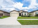 Inviting single-story home featuring a two-car garage and a well-maintained front lawn at 8710 Rindge Rd, Polk City, FL 33868