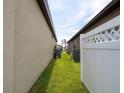 Side yard featuring healthy grass, privacy fence, and space between houses at 8710 Rindge Rd, Polk City, FL 33868