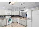Well-equipped kitchen with white appliances, granite countertops, and a view to the dining area at 891 Licaria Dr, Ocoee, FL 34761