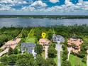 Aerial view of an estate home surrounded by lush greenery and a serene lake at 9253 Tibet Pointe Cir, Windermere, FL 34786