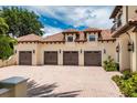 Spacious three-car garage with brick-paved driveway and Mediterranean-style architecture at 9253 Tibet Pointe Cir, Windermere, FL 34786