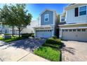 View of the townhome with a two-car garage and brick paved driveway plus lawn at 978 E 10Th St, Apopka, FL 32703