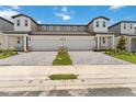 Front view of a multi-Gathering townhouse with a paver driveway and well maintained lawn at 1793 Archer Dr, Minneola, FL 34715