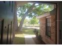 View from the doorway of the front porch looking out at the yard with a tall tree and partial view of the neighbor's house at 2181 Wekiwa Oaks Dr, Apopka, FL 32703