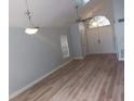 Open-concept living room with vaulted ceilings, light hardwood floors, stylish light fixtures, and access to other rooms at 2181 Wekiwa Oaks Dr, Apopka, FL 32703