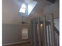 Open-concept living room featuring vaulted ceilings, a skylight, and light hardwood floors with the staircase visible at 2181 Wekiwa Oaks Dr, Apopka, FL 32703
