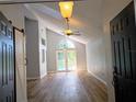 Inviting living room with wood floors, vaulted ceiling, and sliding doors leading to the pool at 2181 Wekiwa Oaks Dr, Apopka, FL 32703