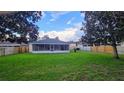 Expansive backyard with lush green grass, screened-in lanai, and privacy fence at 2555 Palmetto Ridge Cir, Apopka, FL 32712