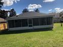 A large screened in patio area offers outdoor enjoyment, with a spacious grassy lawn and a partial fence at 2555 Palmetto Ridge Cir, Apopka, FL 32712