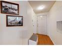 Inviting hallway with white walls, wood floors, and decorative art at 2598 Robert Trent Jones Dr # 1030, Orlando, FL 32835