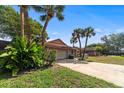 Well-maintained home with a two-car garage, palm trees, and a driveway leading to the entrance at 2715 Wekiva Meadows Ct, Apopka, FL 32712