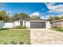 Classic home featuring gray garage door, manicured shrubs, and freshly painted exterior at 3822 Janie Ct, Orlando, FL 32822