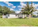 A view of the side of the home with a large yard and mature trees at 3822 Janie Ct, Orlando, FL 32822