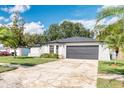 Lovely home with gray garage door, mature palm trees, and freshly painted exterior at 3822 Janie Ct, Orlando, FL 32822