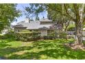 Well-maintained home featuring a manicured lawn and mature trees shading the front of the house at 4030 Cool Water Ct, Winter Park, FL 32792