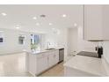Modern kitchen with white cabinets, stainless steel appliances, and an island with a sink at 4325 Switchgrass Ln, St Cloud, FL 34772