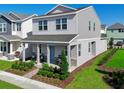 Stylish two-story home showcasing a welcoming front porch, landscaped garden, and charming architectural details at 490 Belmond Dr, Debary, FL 32713