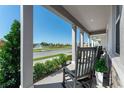 Inviting front porch with comfortable rocking chairs overlooking a tranquil street and water fountain feature at 490 Belmond Dr, Debary, FL 32713