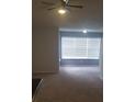 Inviting living room with large windows, neutral carpet, and ceiling fan providing ample natural light and comfort at 5160 Conroy Rd # 1437, Orlando, FL 32811