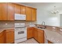 Well-lit kitchen showcasing wood cabinets, granite countertops, and modern appliances at 5843 Strada Capri Way, Orlando, FL 32835