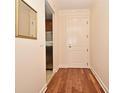 Hallway with wood floors leading to a door, with a glimpse of stainless steel appliances in the nearby kitchen at 630 Vassar St # 2508, Orlando, FL 32804