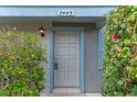 Close-up of the front door, featuring a grey painted door, exterior light, and digital lock at 7449 Daniel Webster Dr # 3, Winter Park, FL 32792