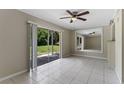 Open living room with neutral walls, ceiling fan, and sliding glass doors to the patio at 7449 Daniel Webster Dr # 3, Winter Park, FL 32792