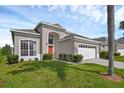 Two-story home with a bright red front door and a two-car garage at 8113 Sun Palm Dr, Kissimmee, FL 34747