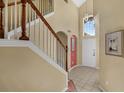 Inviting foyer with tiled floors, staircase, and a high ceiling with a hanging light fixture at 8113 Sun Palm Dr, Kissimmee, FL 34747