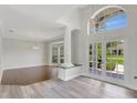 Bright foyer featuring high ceilings, a decorative column, and french doors with natural light at 8623 Summerville Pl, Orlando, FL 32819